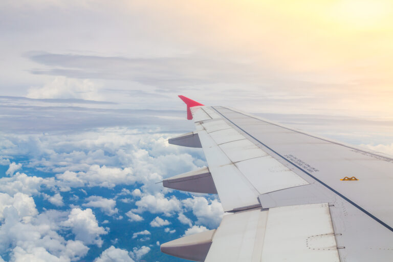 Wing of an airplane flying above the clouds