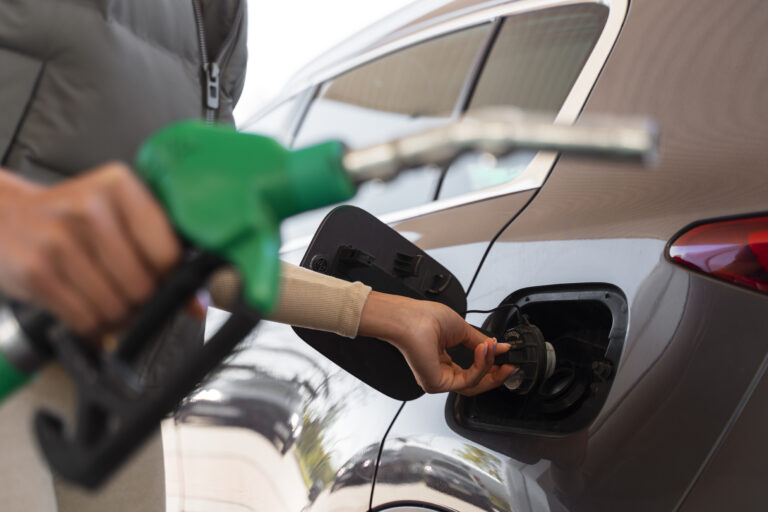 vista-da-mulher-com-carro-no-posto-de-gasolina