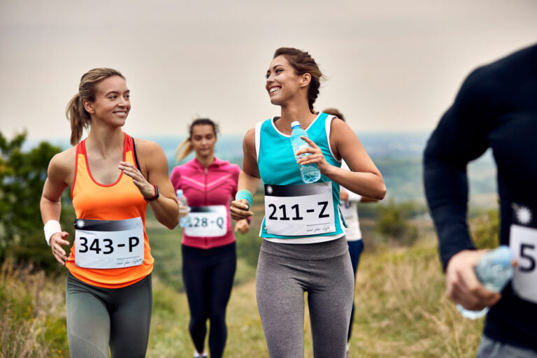 Young happy athletic women running a marathon in nature